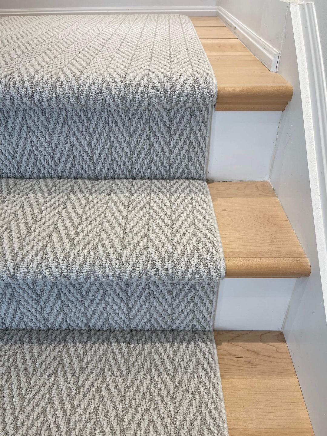 Step detail of Anderson Tuftex Fossil Herringbone Stair Runner Canada in taupe-gray tones