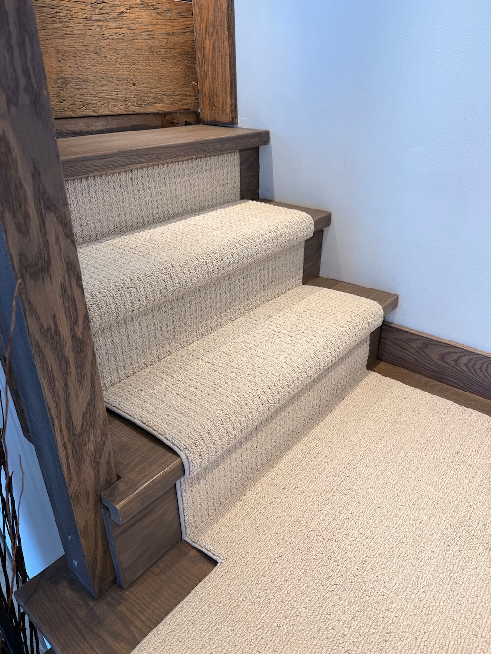 carpeted staircase with wooden risers