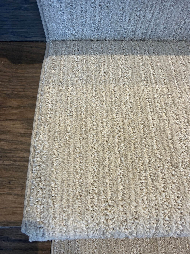 Sewn-edge binding on beige stair runner over hardwood