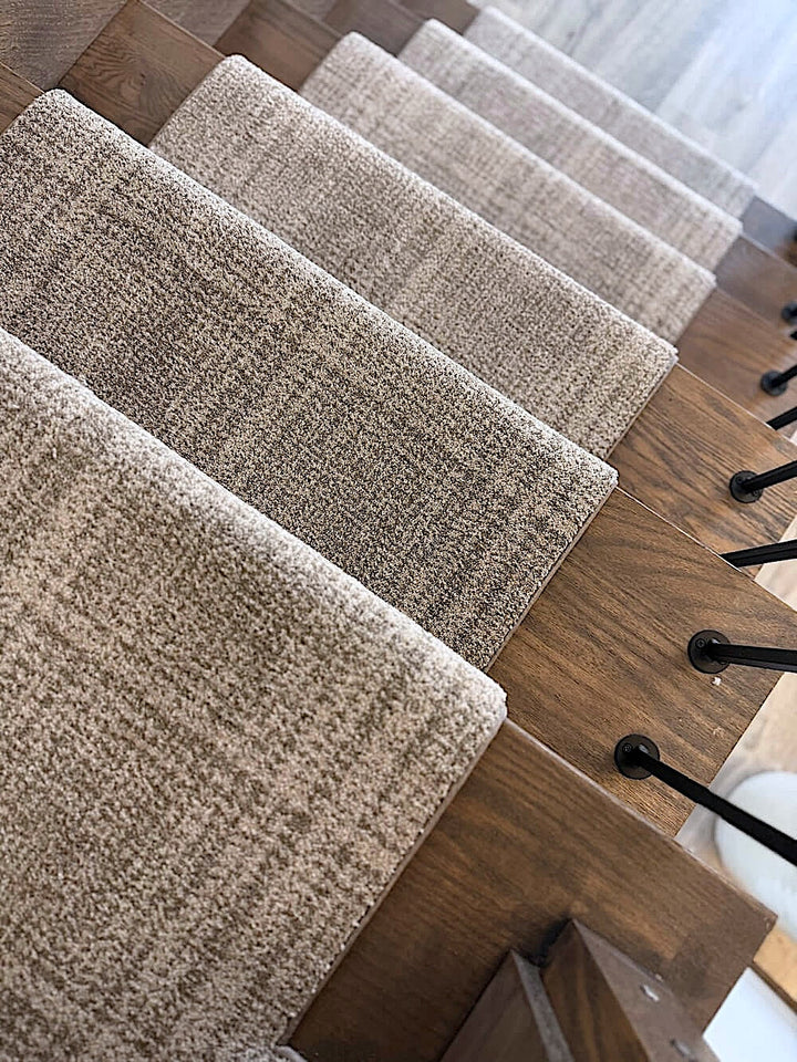 Beige carpeted staircase with wooden steps