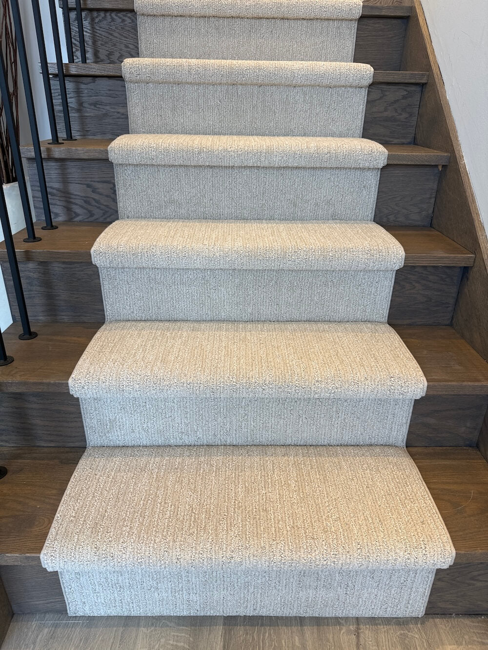 Modern beige stair runner installed on gray wood stairs