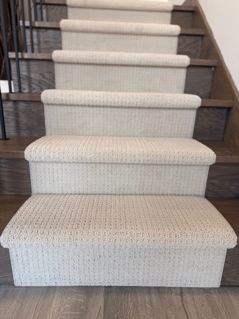 beige stair runner carpeting on dark wood stairs